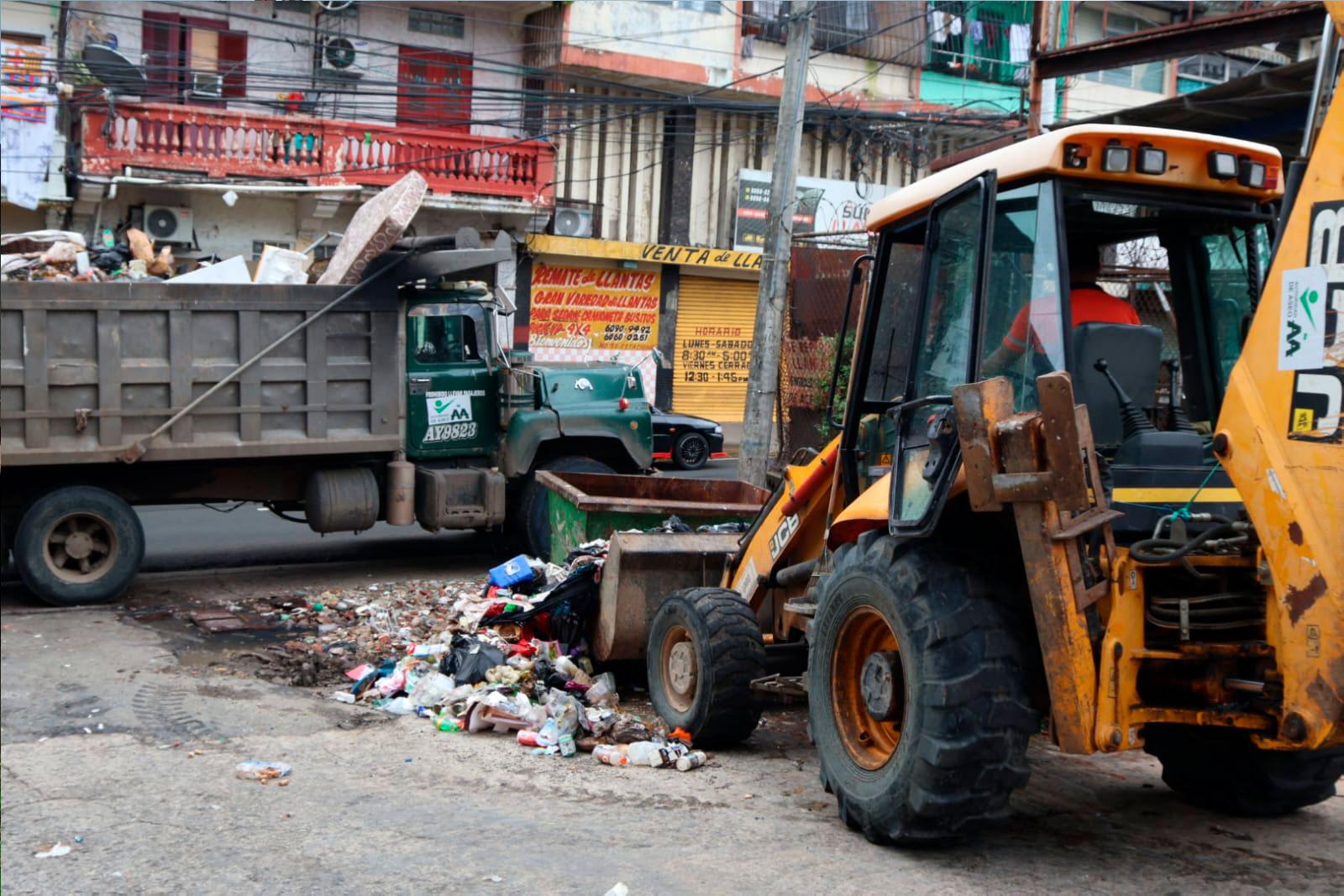 Retroexcavadora y volquete en proceso de recolección de desechos en Santa Ana